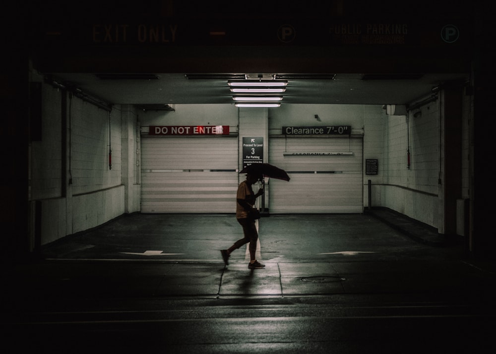 man in black jacket walking on tunnel