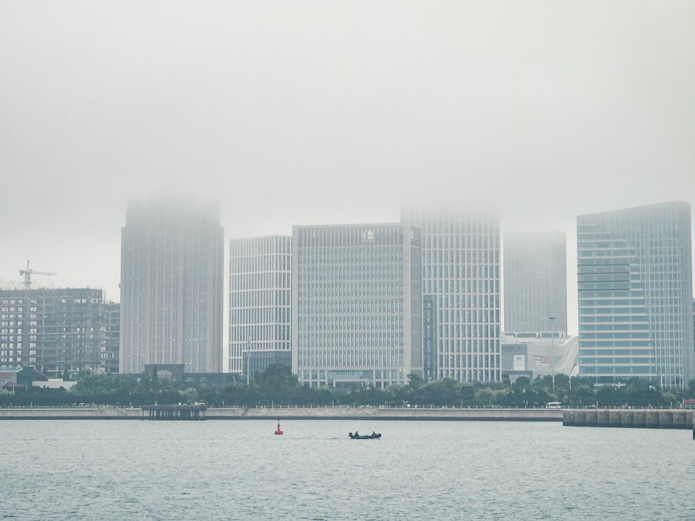 white boat on sea near city buildings during daytime