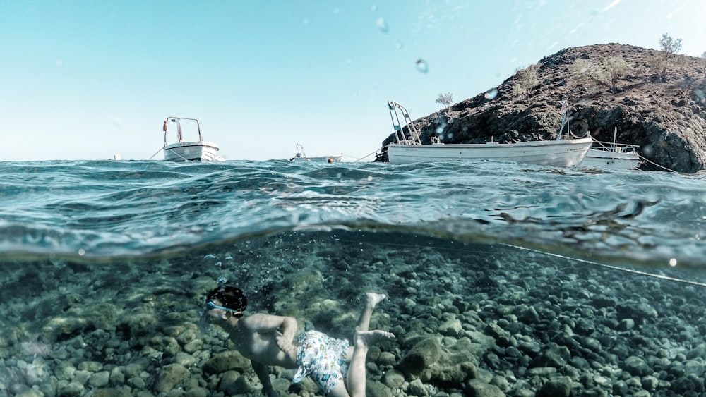 Frau im weißen Bikini schwimmt tagsüber auf dem Meer