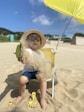 girl in white dress sitting on white chair on beach during daytime