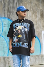 boy in black crew neck oversized t-shirt standing near wall