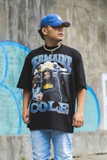 boy in black crew neck oversized t-shirt standing near wall