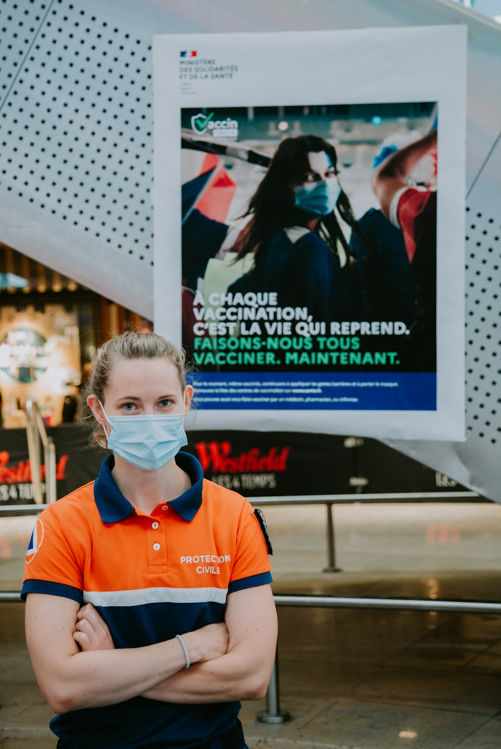 man in orange and white polo shirt wearing white mask