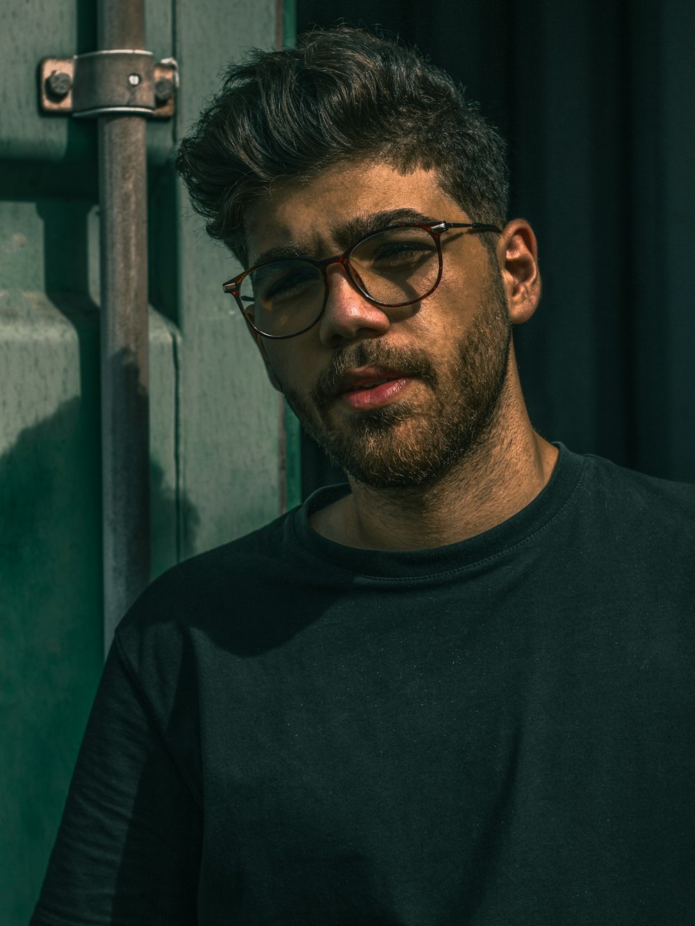 man in black crew neck shirt wearing black framed eyeglasses