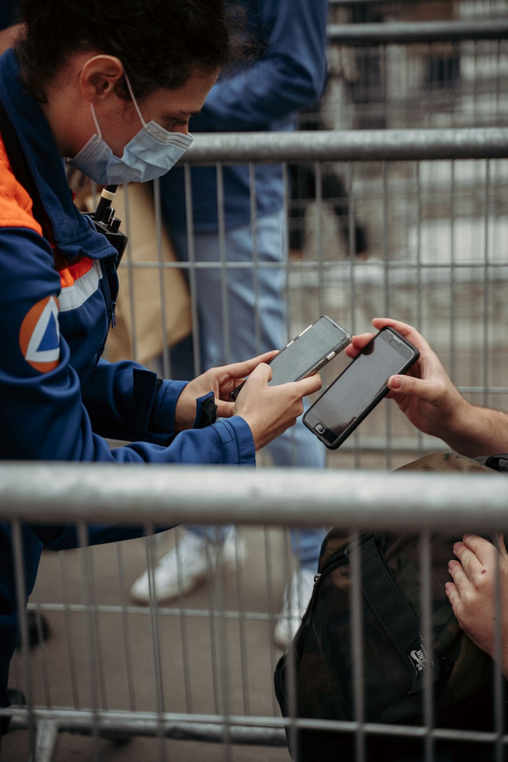 person in blue and orange jacket holding silver ipad
