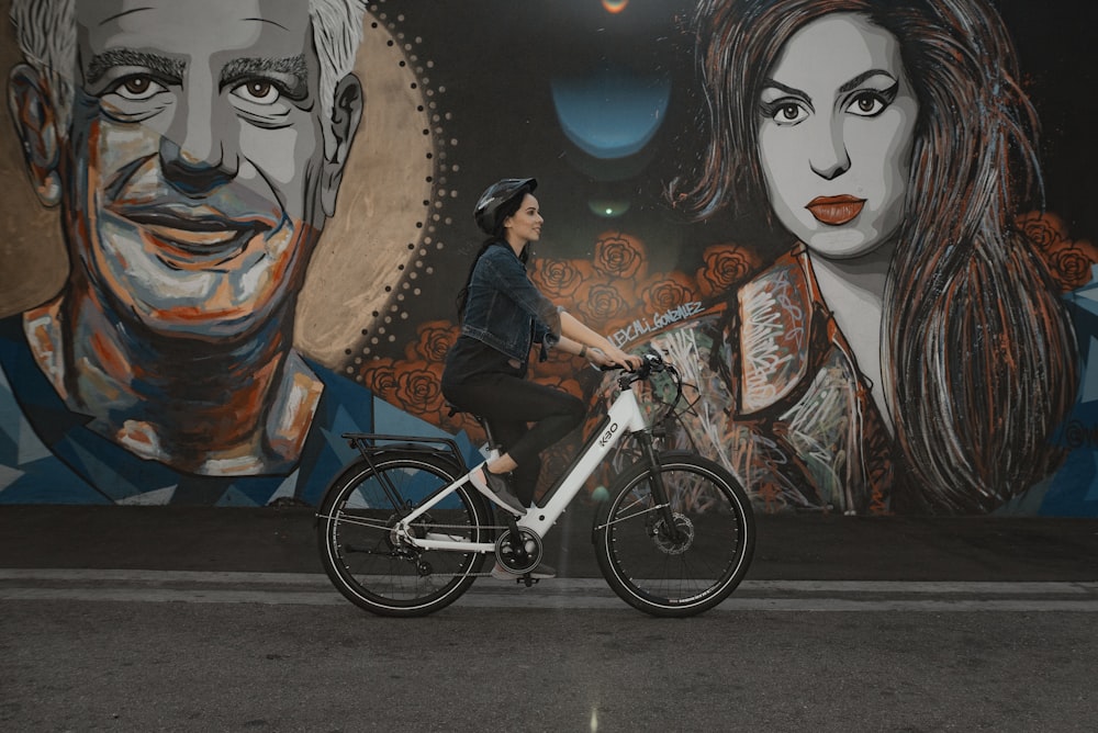 man in black jacket riding on blue bicycle