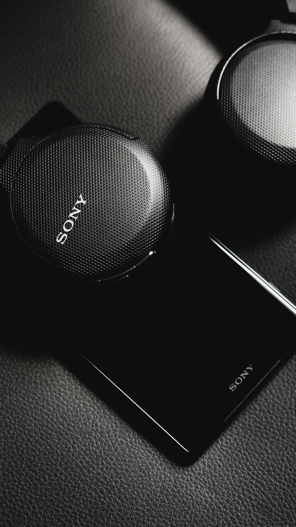 black sony portable speaker beside white smartphone