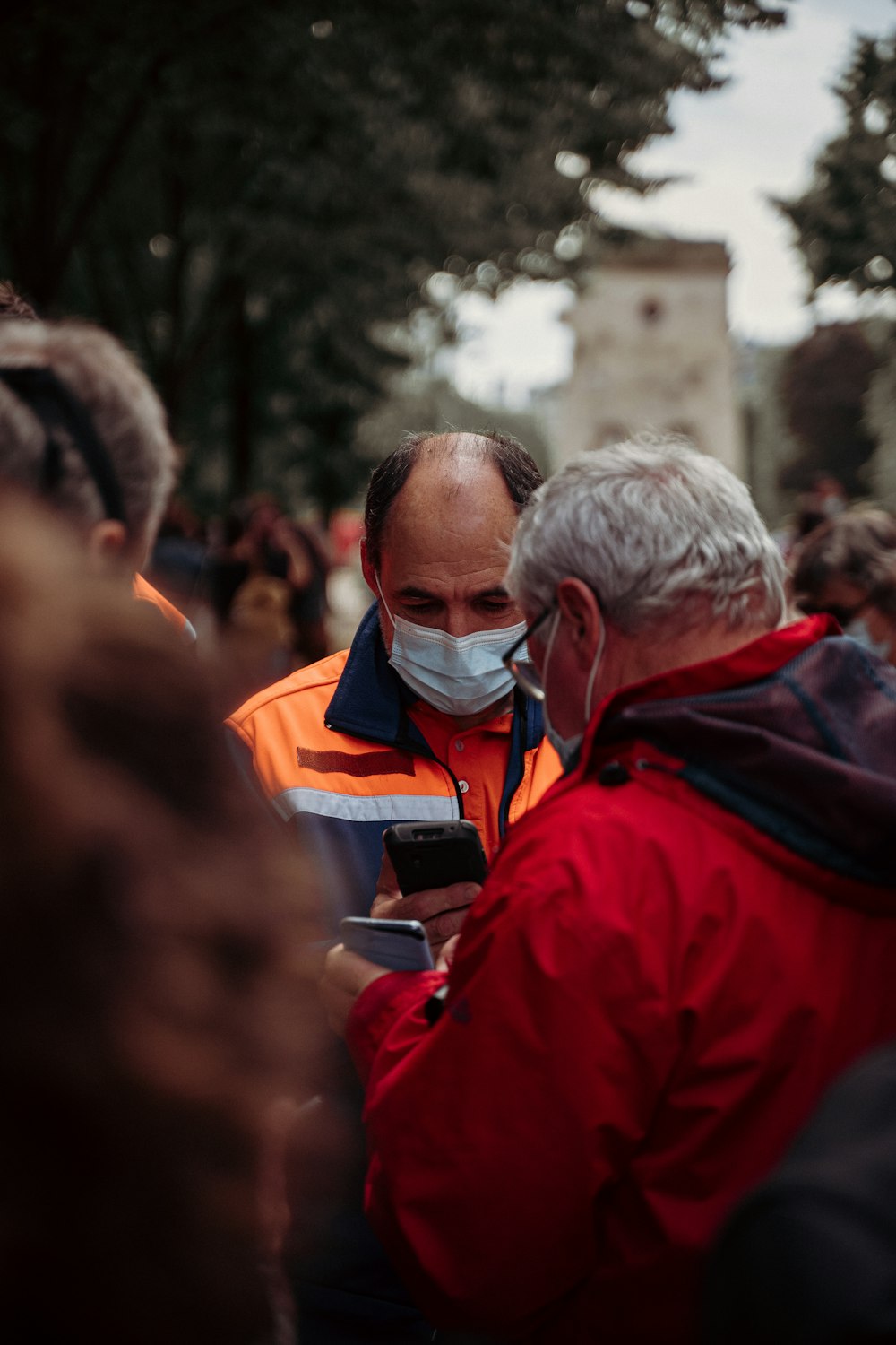 man in red jacket wearing white mask