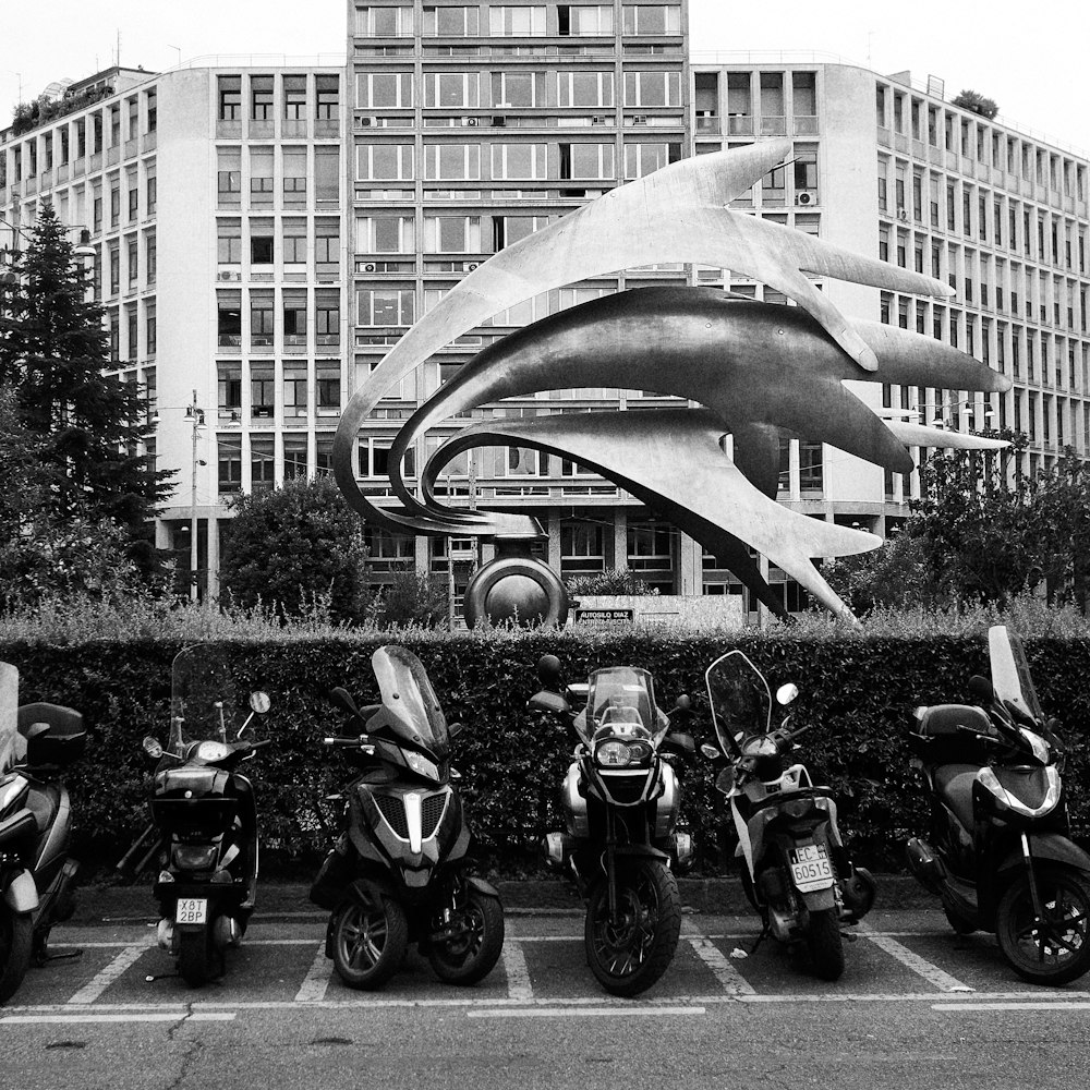 grayscale photo of motorcycle parked near building