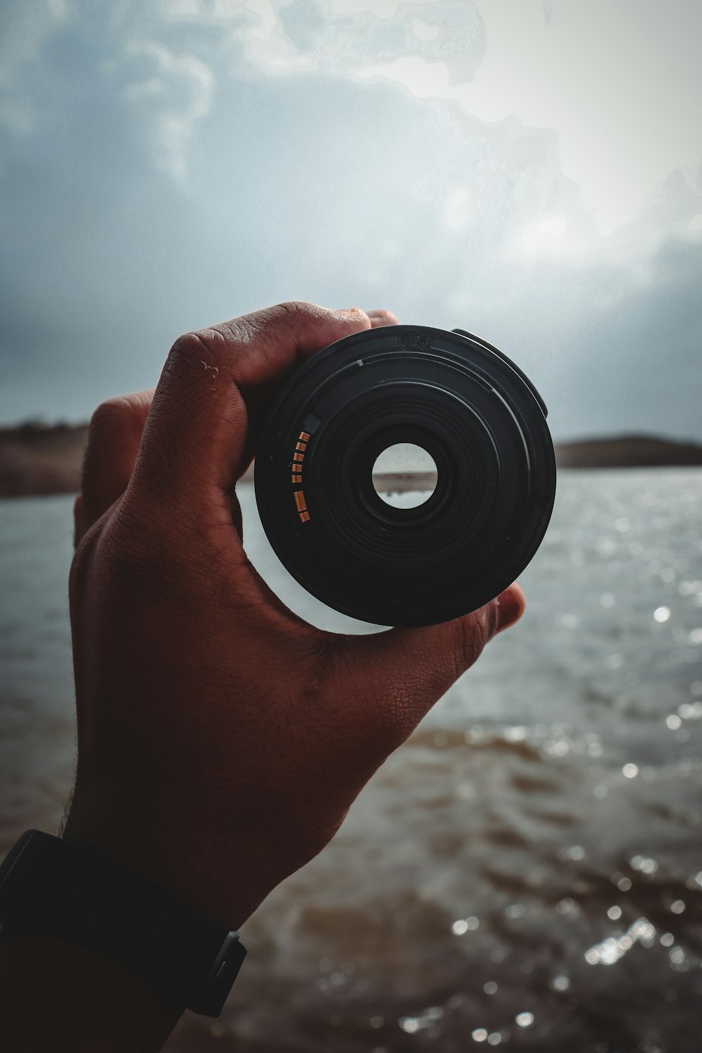 person holding black camera lens