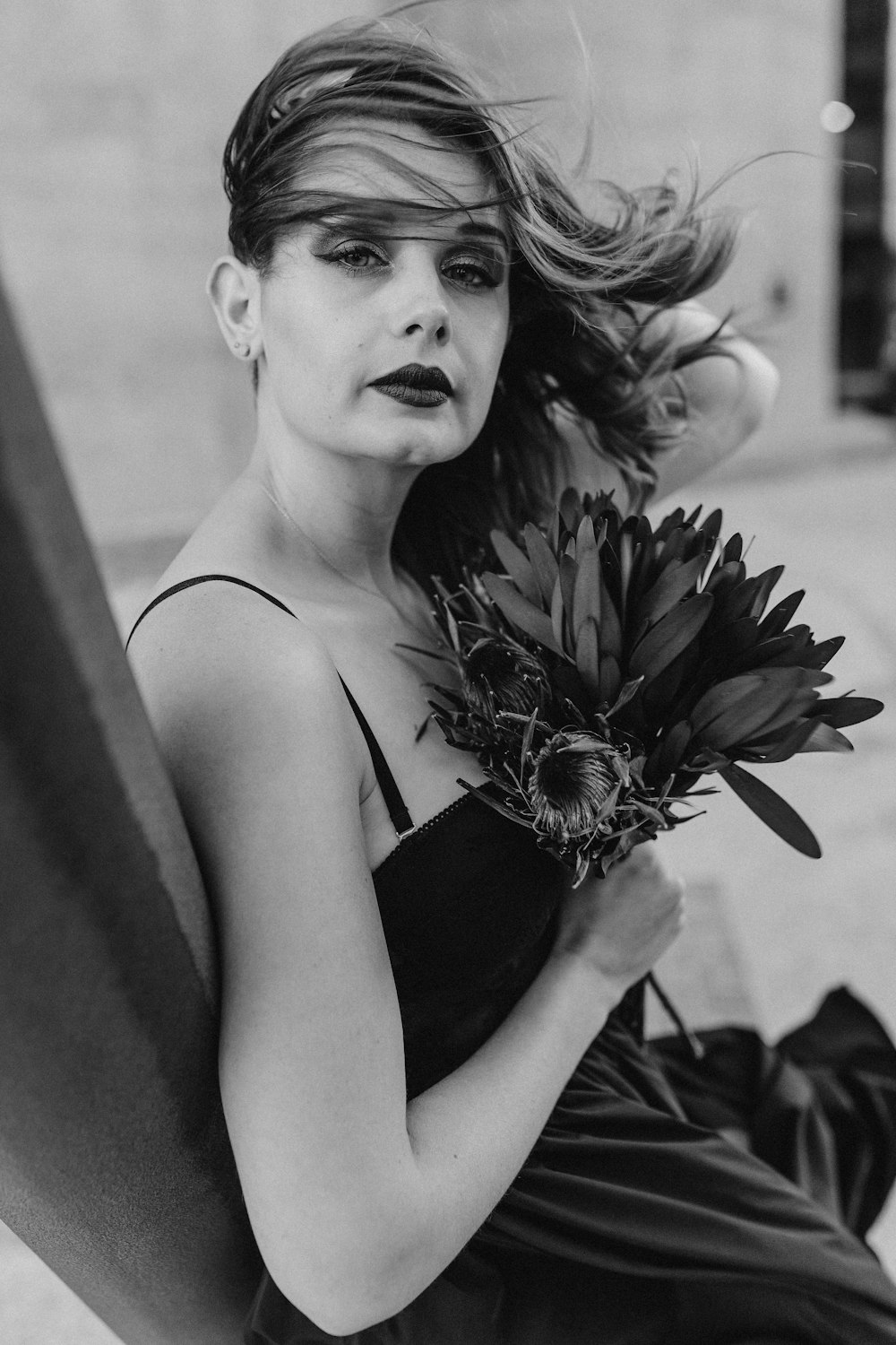 woman in black tank top holding flower