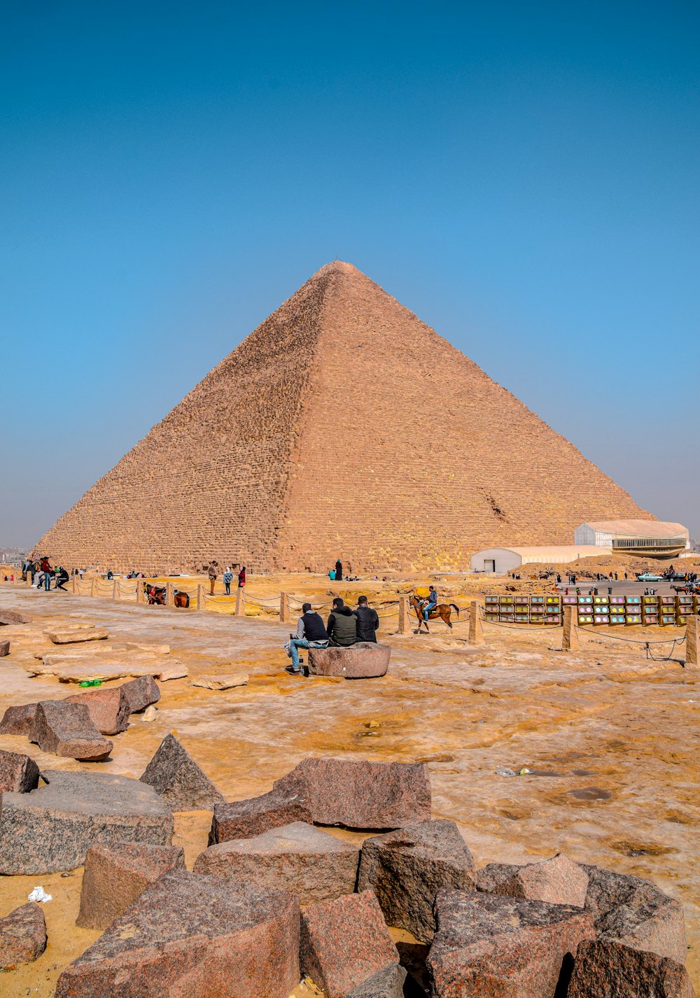Menschen, die tagsüber in der Nähe der Pyramide unter blauem Himmel stehen