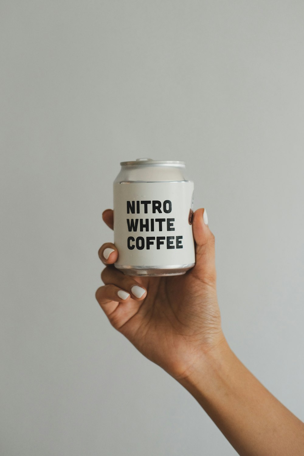 person holding white and black labeled cup