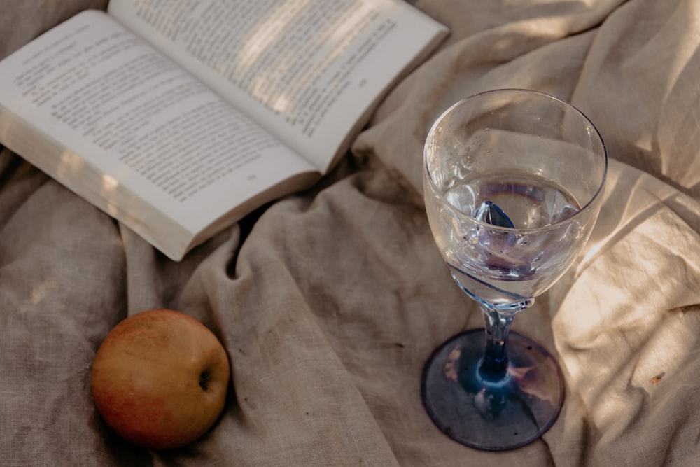 clear wine glass beside apple fruit