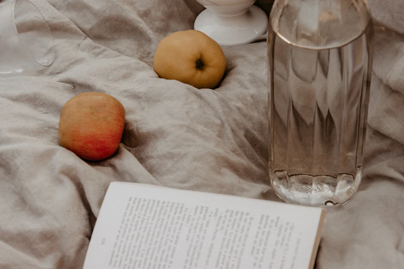 An open book and a glass of water on linen