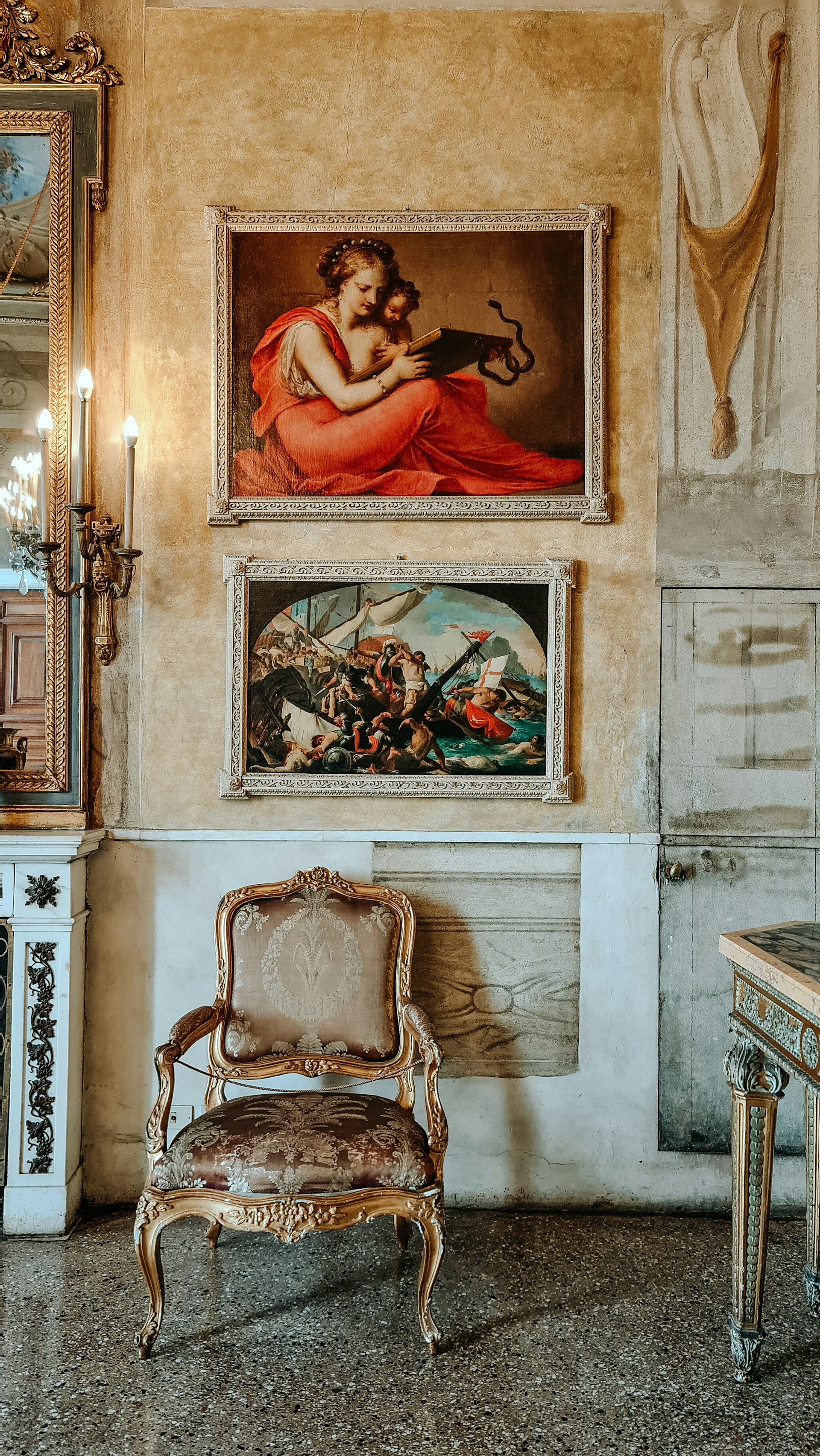 Elegant interior of the luxury Navigli apartment showcasing a wall adorned with historical Milanese paintings under warm, ambient lighting.