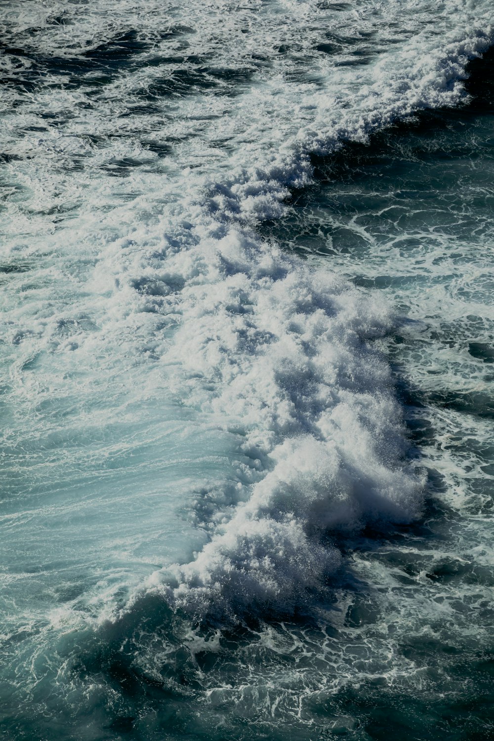 ocean waves crashing on shore during daytime