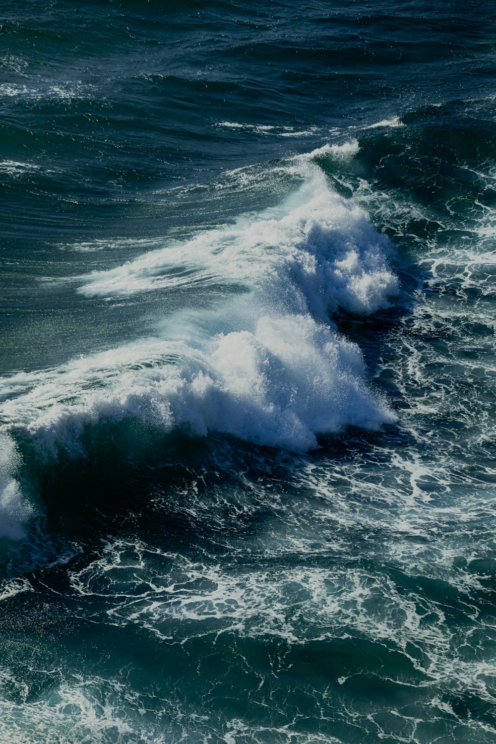 ocean waves crashing on rocks during daytime