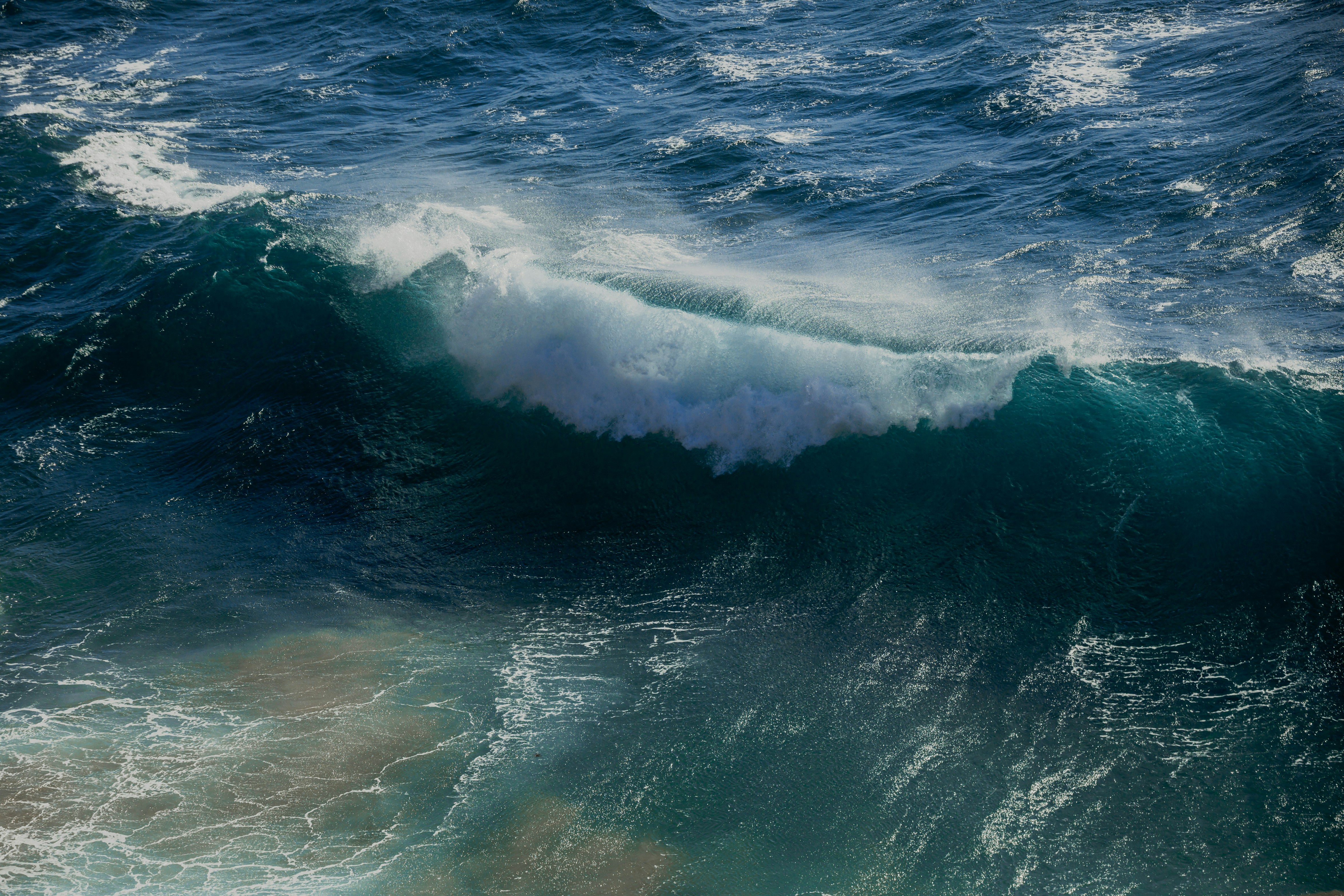ocean waves crashing on shore during daytime