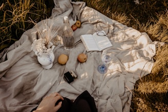 A quiet moment capturing a warm flask resting beside a pastel blue picnic basket on a soft green lawn.