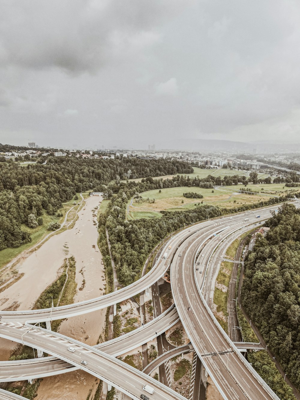 aerial view of road between green trees during daytime