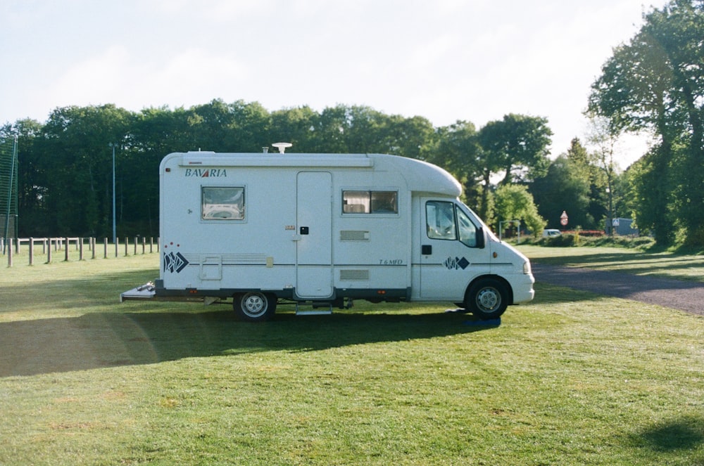 white and blue van on green grass field during daytime