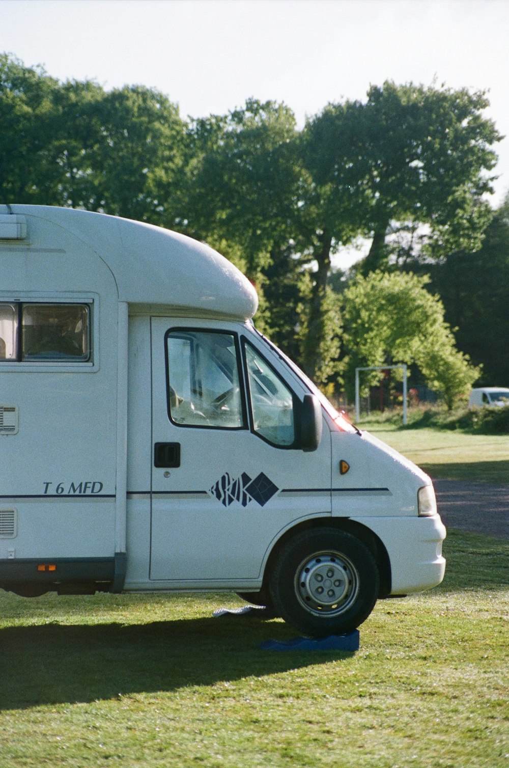 white and blue van on green grass field during daytime