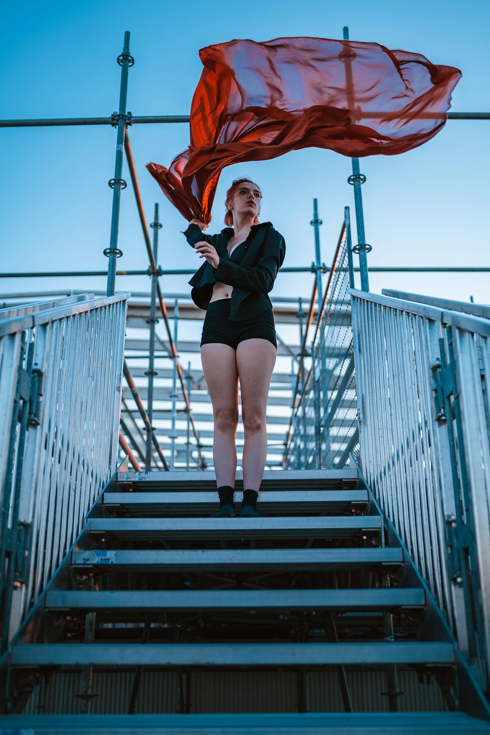 woman in black tank top and black leggings walking on wooden bridge during daytime