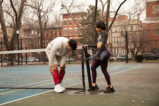 man in white long sleeve shirt and red pants playing basketball during daytime