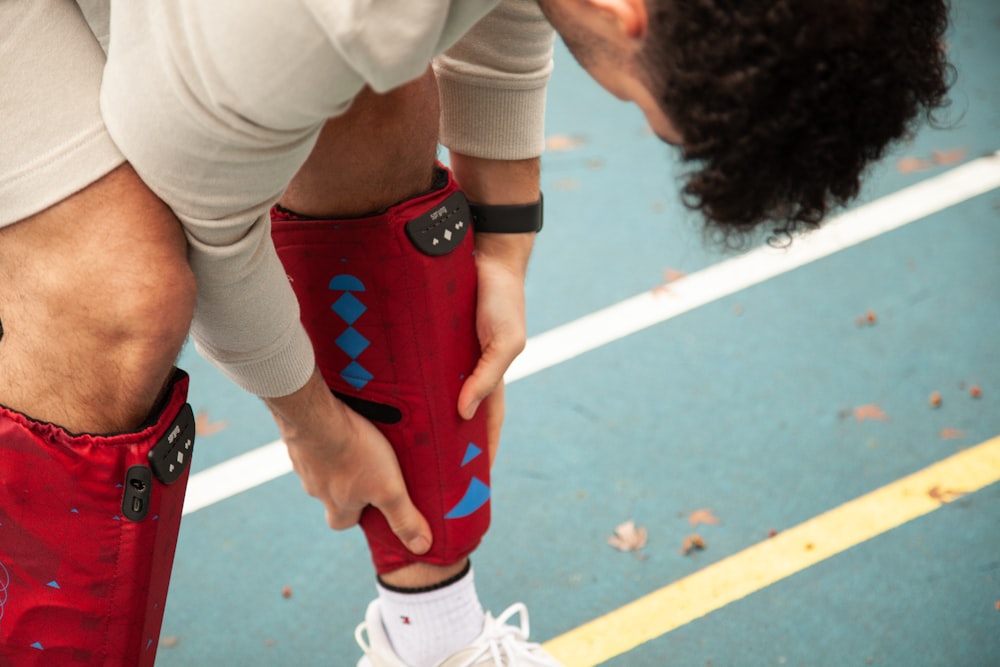 person in white shirt and red shorts wearing white nike sneakers