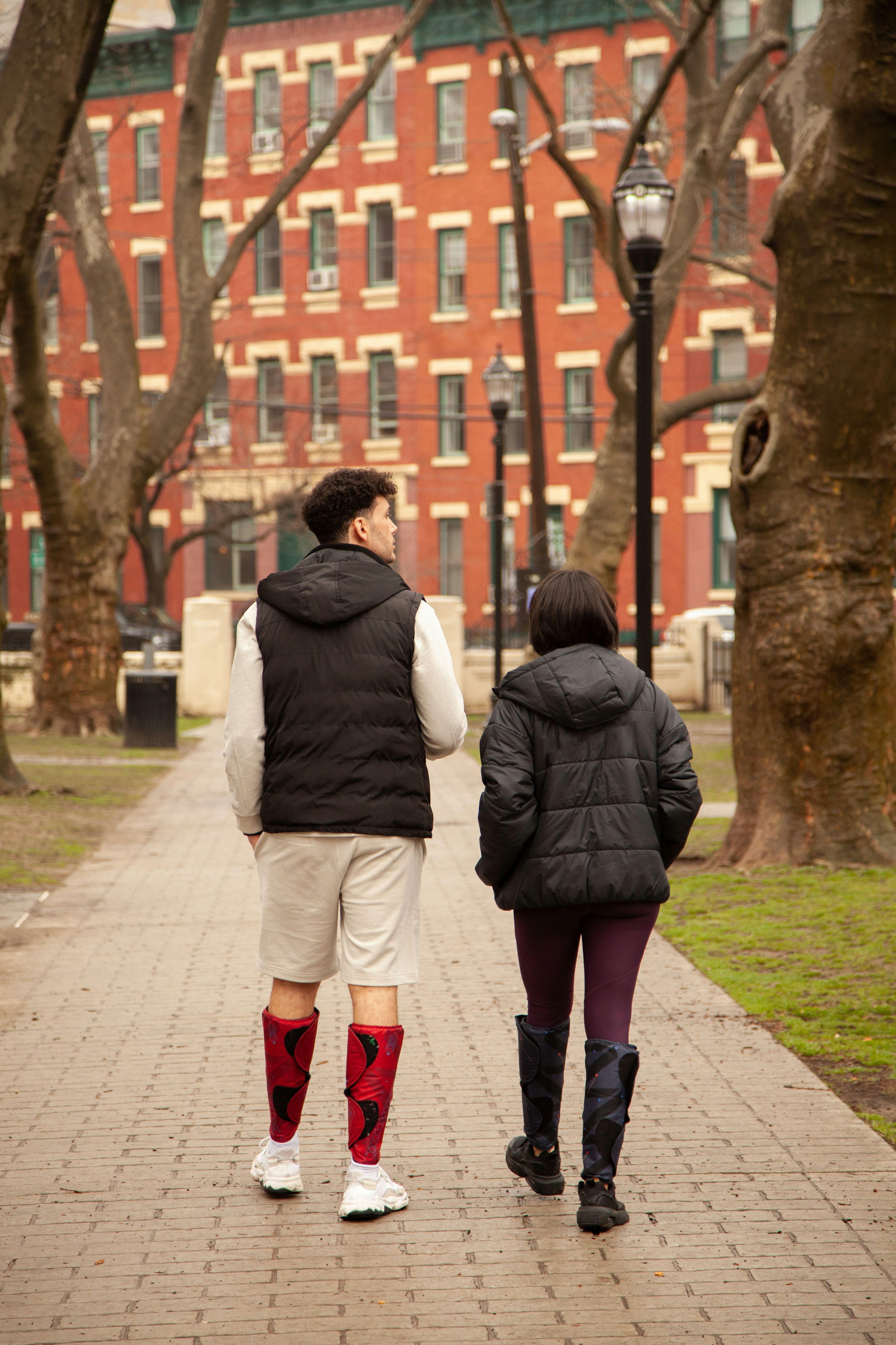couple walking on sidewalk during daytime