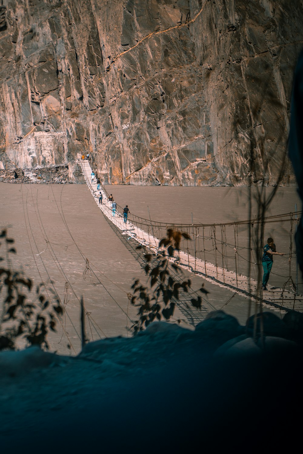 people walking on bridge covered with snow during daytime