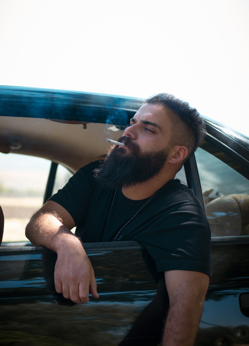 man in black crew neck t-shirt sitting on car seat