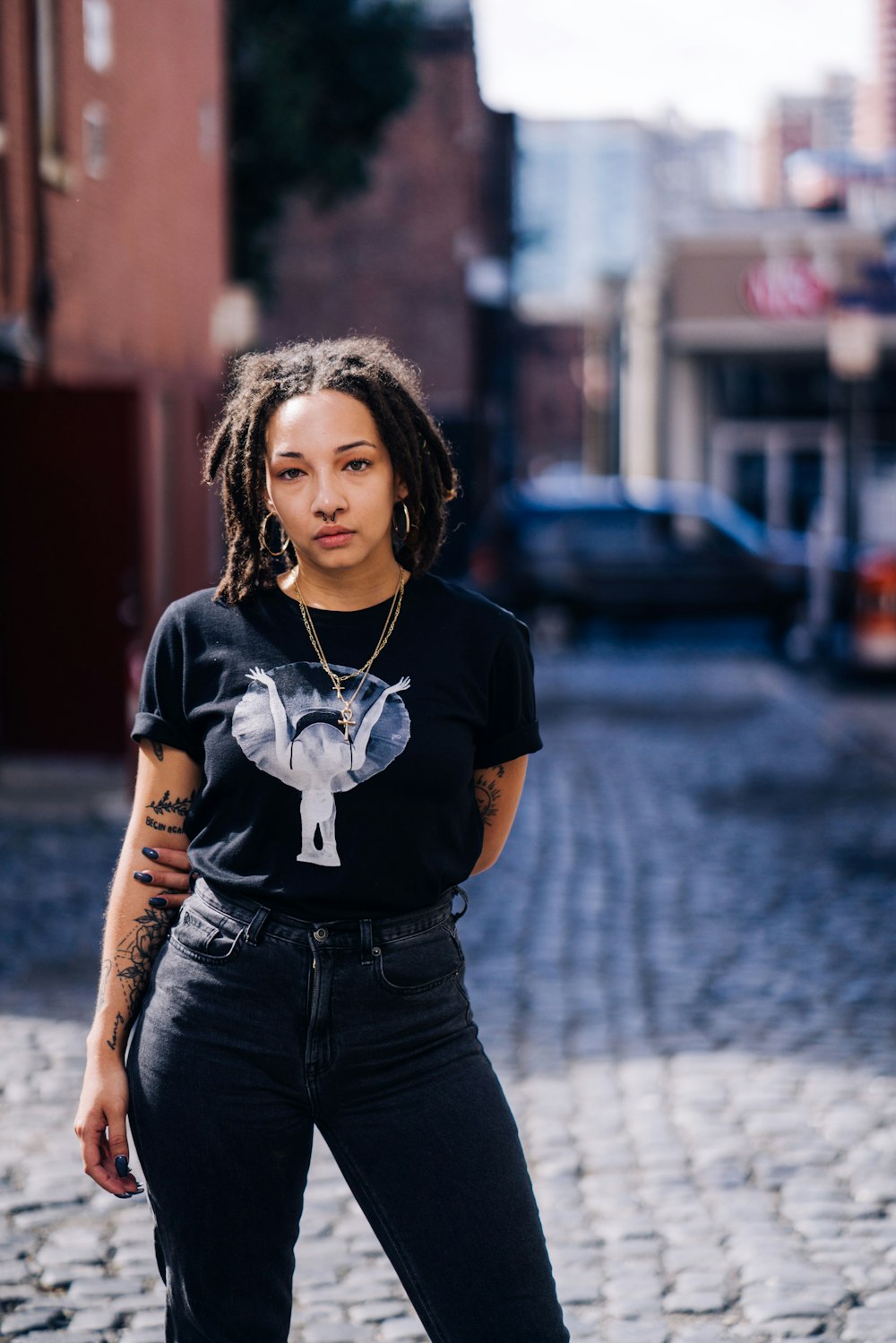 woman in black and white crew neck t-shirt and black denim shorts standing on street