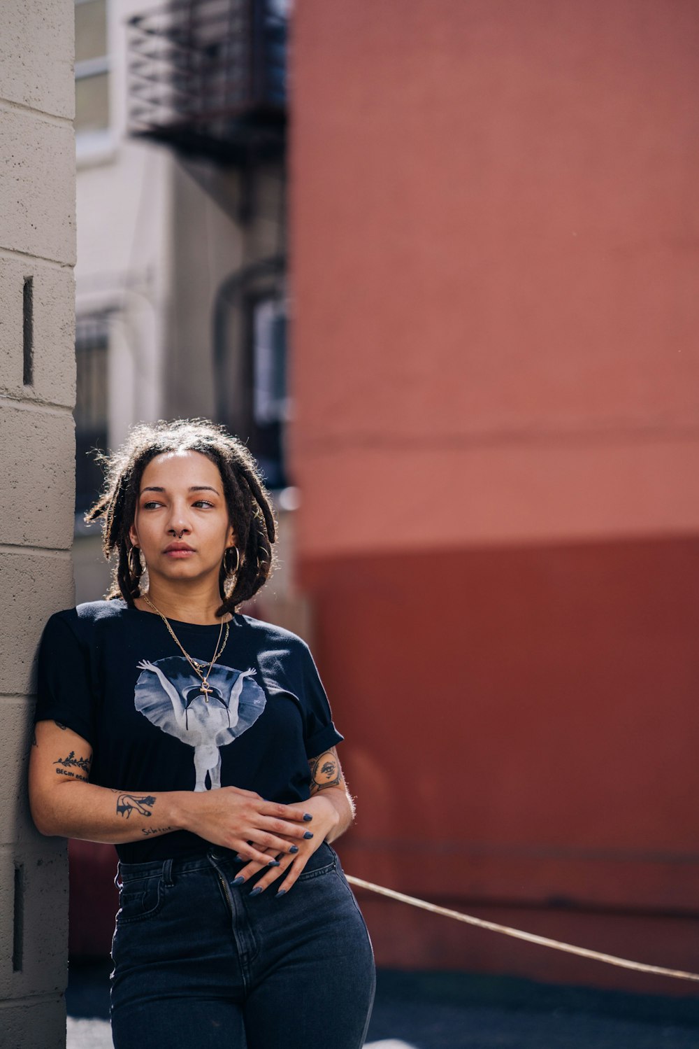 woman in blue crew neck t-shirt standing near red wall