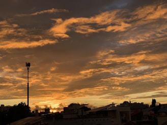 Photographer capturing a dramatic sunset behind a skyline filled with antennas and satellite dishes.