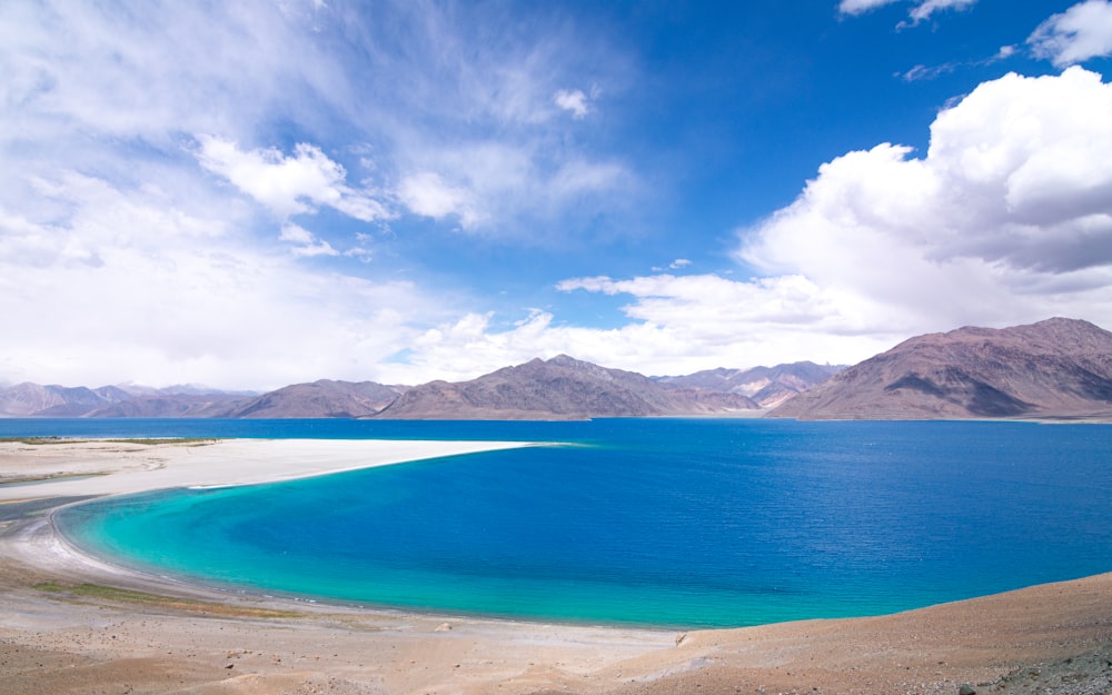 blue sea near mountain under blue sky during daytime