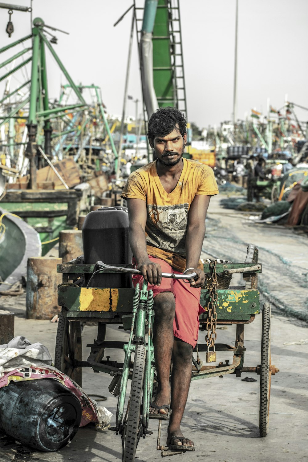 man in black crew neck t-shirt and red shorts sitting on red and green metal