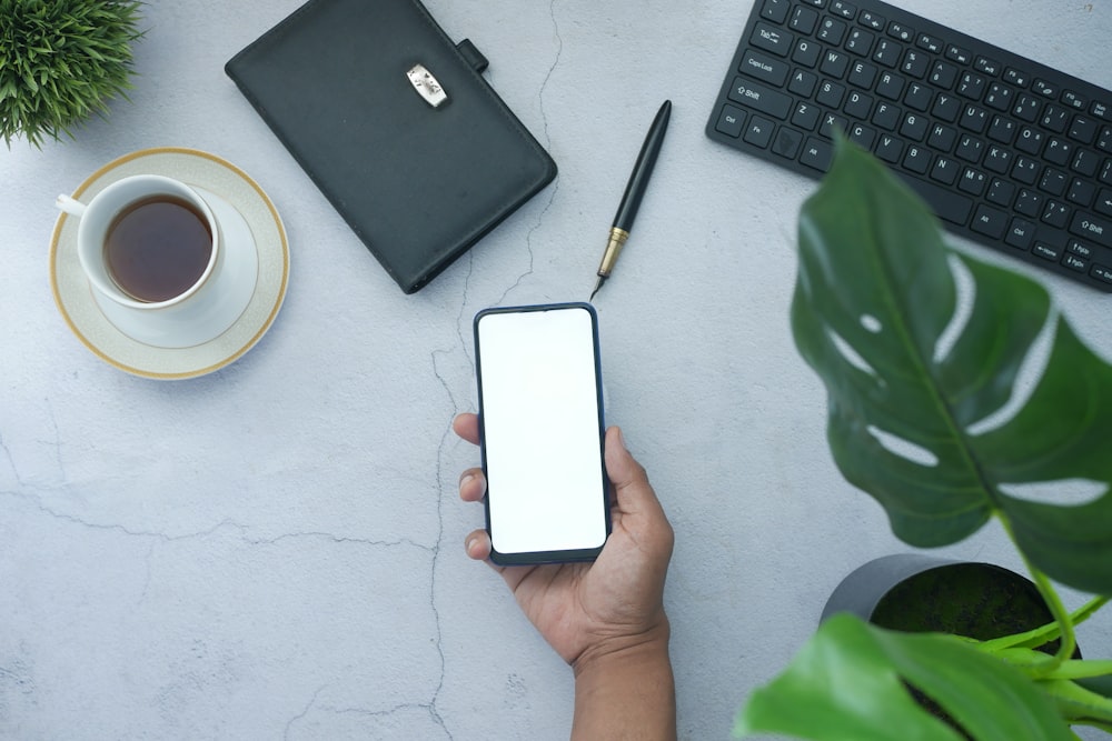 person holding white box near black laptop computer