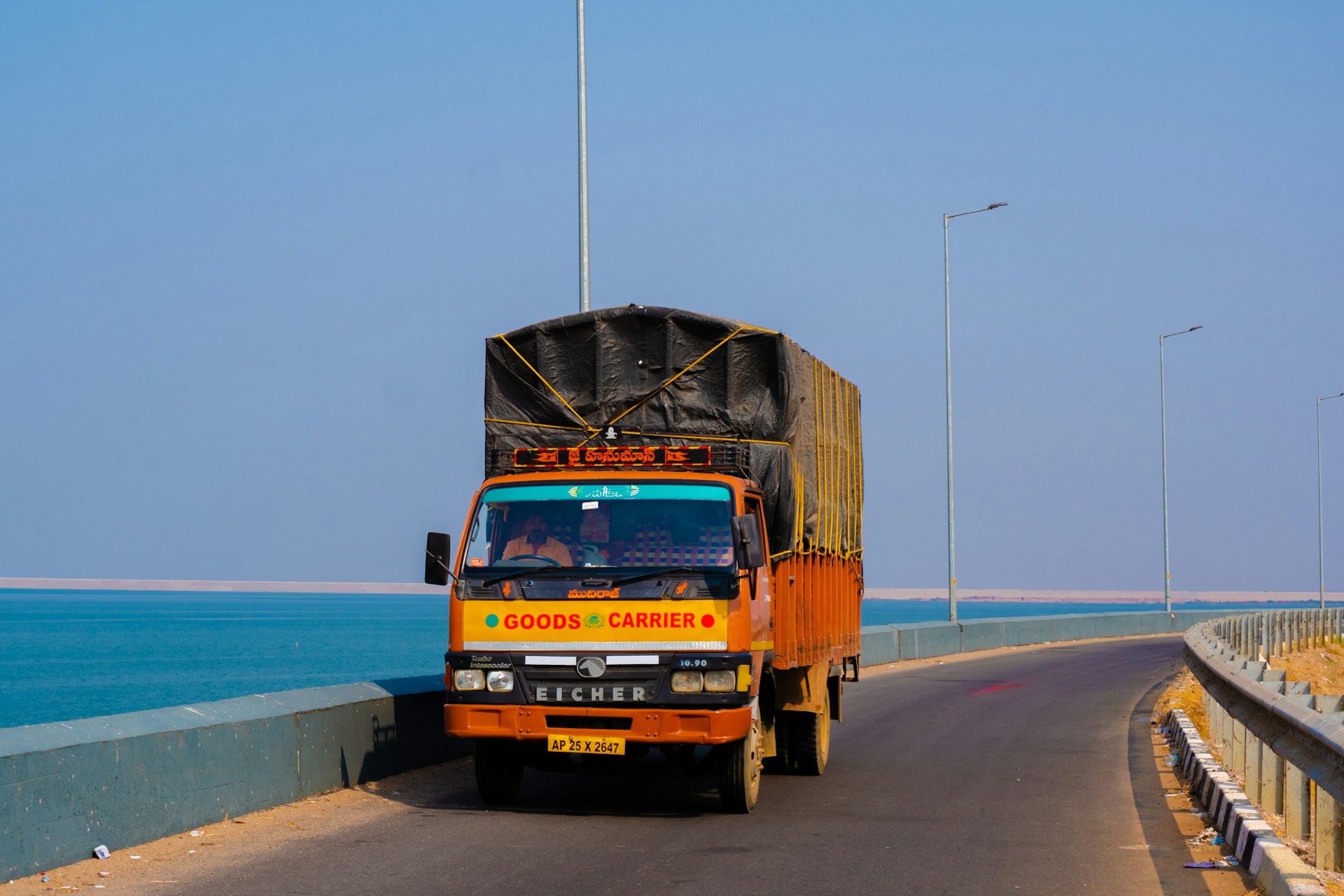orange and black truck on road near sea during daytime