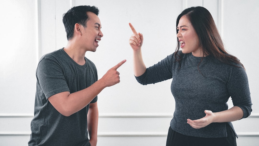 man in gray crew neck long sleeve shirt standing beside woman in black crew neck shirt, Couple fight each other