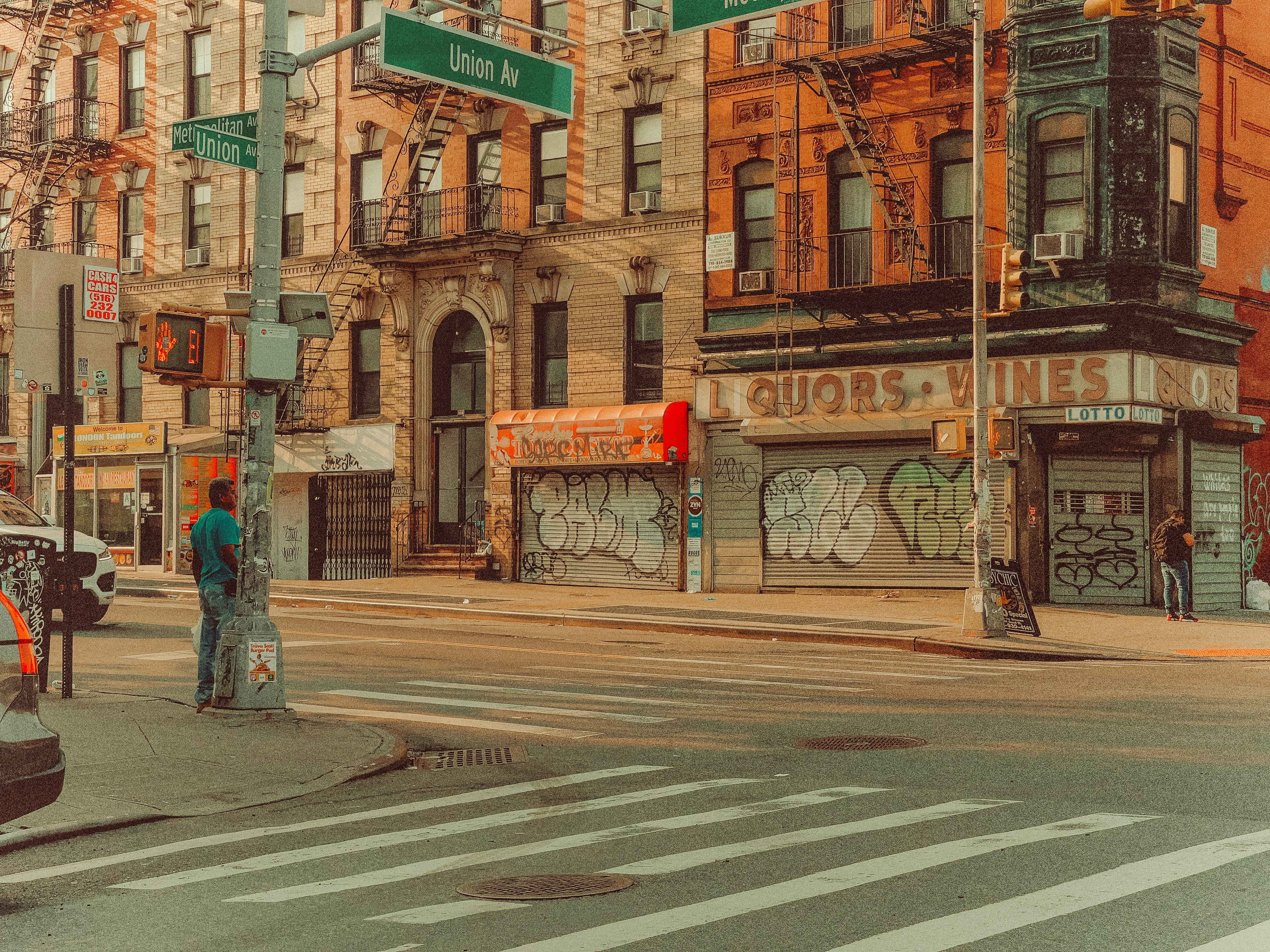 man in blue denim jeans standing on pedestrian lane during daytime, 