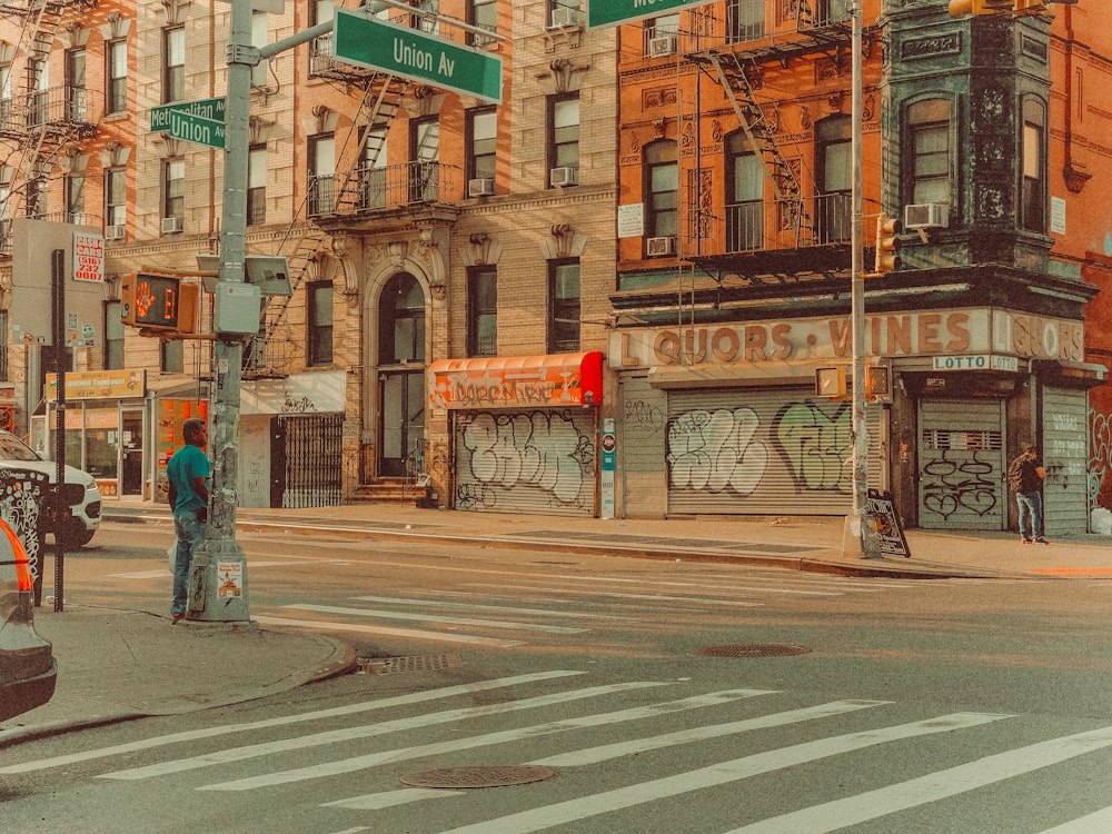 man in blue denim jeans standing on pedestrian lane during daytime