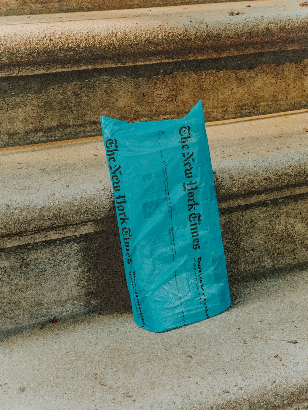 blue plastic pack on gray concrete stairs