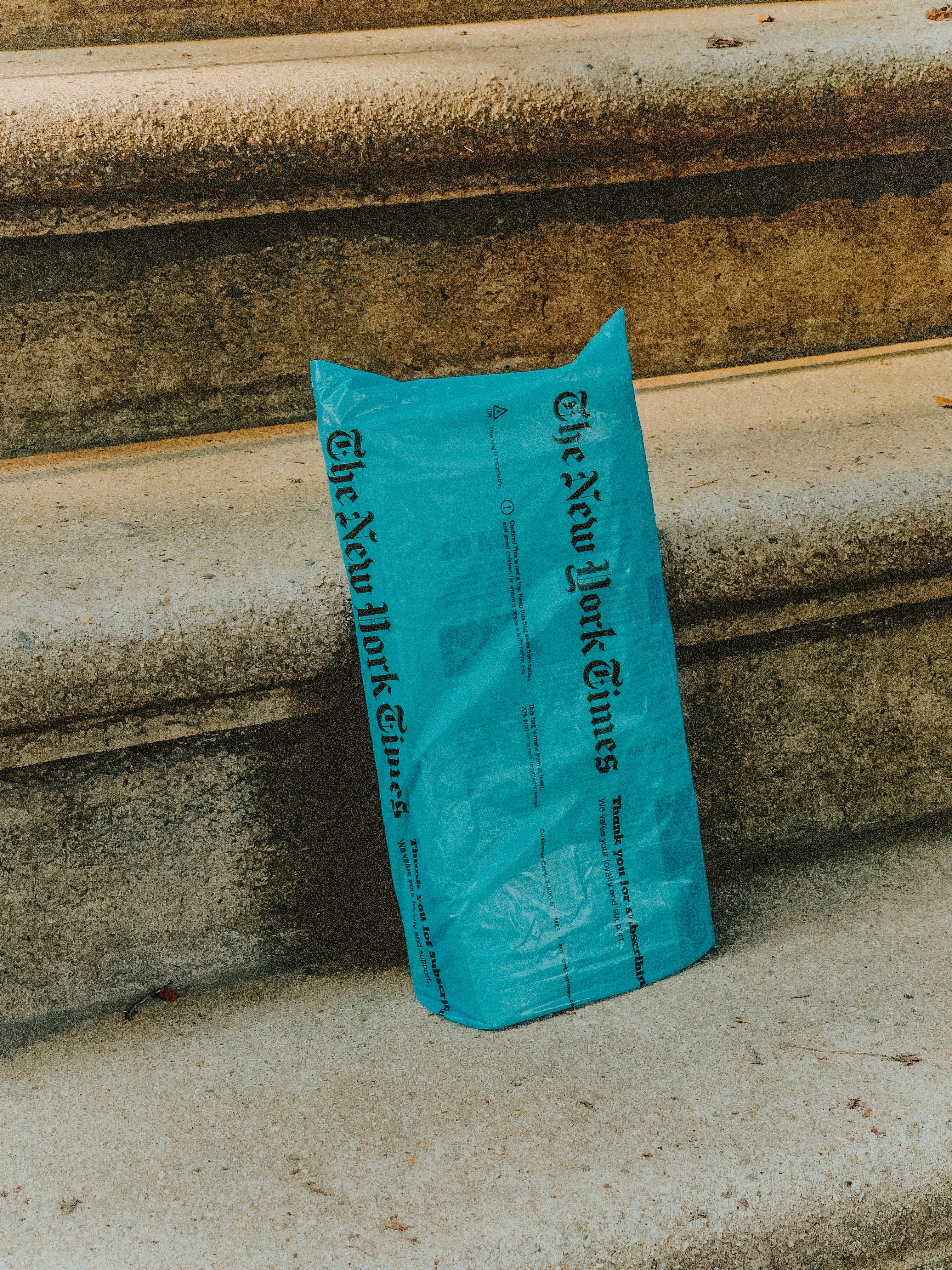 blue plastic pack on gray concrete stairs