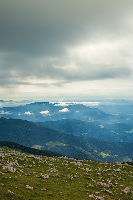 green mountains under white clouds during daytime in Raduha Slovenia