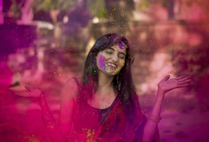 woman in pink long sleeve shirt with blue and green powder on her face