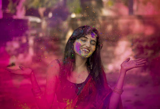 woman in pink long sleeve shirt with blue and green powder on her face
