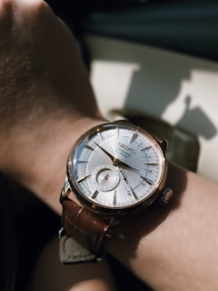 Elegant wrist wearing a classic artisan watch in natural daylight highlighting its craftsmanship.