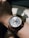 Close-up of a luxury wristwatch on a wrist with natural light highlighting its details.